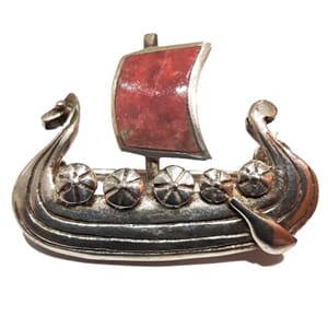 Brosje i sølv med vikingskip-motiv